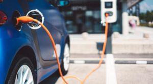 orange cable charging a blue electric vehicle